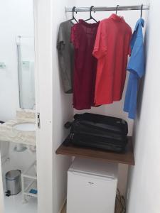 a bathroom with a closet with red and blue clothes at Pousada Aconchego dos Gerânios in Paraty