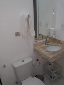a bathroom with a white toilet and a sink at Pousada Aconchego dos Gerânios in Paraty