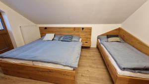 two twin beds in a bedroom with wooden floors at Mytho 1 in Mýto pod Ďumbierom