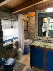 a bathroom with a sink and a toilet and a mirror at Hermosa cabaña en el bosque in Tres Marías