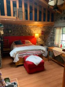 a bedroom with a bed and a red ottoman in a room at Hermosa cabaña en el bosque in Tres Marías