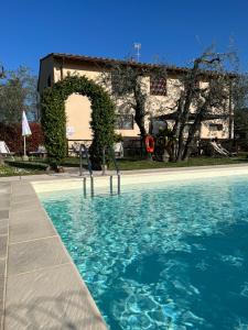 a swimming pool with a building in the background at Agriturismo IL VIAIO in Fiesole