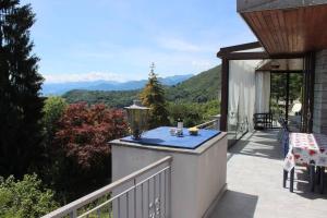 a balcony of a house with a view of the mountains at Il Bell'Ovile, bellissima villa nel verde, con privacy garantita in Novaggio
