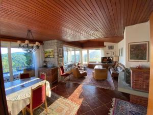 a large living room with a wooden ceiling and a fireplace at Il Bell'Ovile, bellissima villa nel verde, con privacy garantita in Novaggio