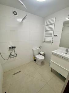 La salle de bains blanche est pourvue de toilettes et d'un lavabo. dans l'établissement Hostel WAWA More, à Varsovie