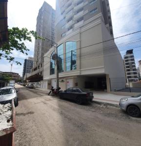 una calle con coches estacionados frente a un edificio en Apto novo Morretes 2 quartos, en Itapema