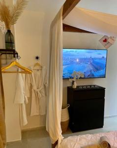 a bedroom with a bed and a window with a tv at Appartement - Spa in Monteux