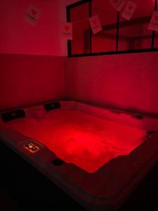 a red room with a bed covered in red light at Appartement - Spa in Monteux