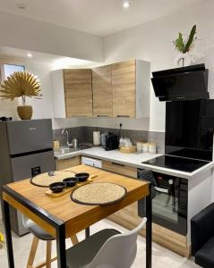 eine Küche mit einem Holztisch und einem Herd Top-Backofen in der Unterkunft Appartement - Spa in Monteux