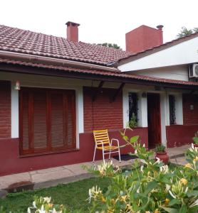 una silla sentada en el porche de una casa en Casa Cristal en Villa General Belgrano