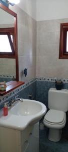 y baño con lavabo, aseo y espejo. en Casa Cristal en Villa General Belgrano