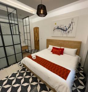 a bedroom with a large white bed with red pillows at CASA LALIQUE in Mexico City