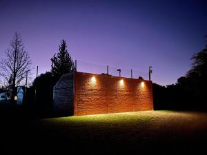 a brick wall with lights on it at night at Cabañas Puerta del Sol - San Marcos Sierras in San Marcos Sierras