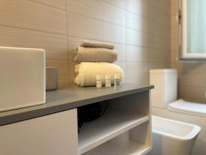 baño con encimera con toallas y lavamanos en Vivapartments MilanoInganni, en Milán