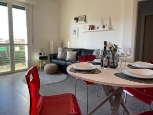sala de estar con mesa y sillas rojas en Vivapartments MilanoInganni, en Milán
