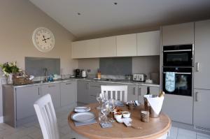 a kitchen with a wooden table and a clock on the wall at Boat House Lodge in Shrewsbury