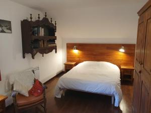 een slaapkamer met een wit bed en een houten hoofdeinde bij Chalet Tante Emma in Vacheresse