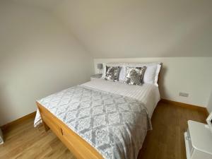 Un dormitorio con una cama grande con almohadas. en LAIRDS COTTAGE, en Stuartfield