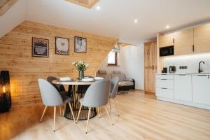 a kitchen and living room with a table and chairs at Novopolka Apartamenty in Rzepiska