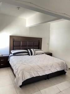 una camera da letto con un grande letto con due cuscini di Hermoso Dpto a pasos del Fashion Drive c/alberca a Monterrey