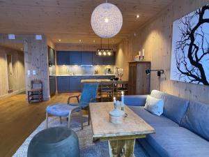 - un salon avec un canapé bleu et une table dans l'établissement Astonishing Mountain Lodge at the top of Gaustablikk, 25m2 west facing terrace, 3 bedrooms, à Gaustablikk