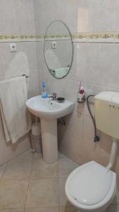 a bathroom with a sink and a toilet and a mirror at Casa de Gá in Mindelo