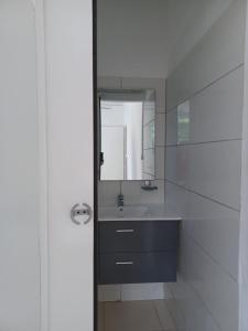 a bathroom with a sink and a mirror at Les Gîtes de Fond Bellemare in Case-Pilote