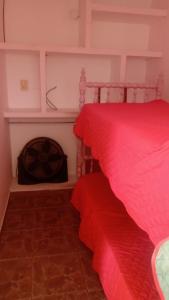 1 dormitorio con cama roja y chimenea en Hermoso departamento céntrico en Salta