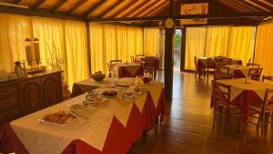 a dining room with two tables with food on them at Motorrad-Hotel Toskana con piscina e giardino nel Chianti in Montespertoli