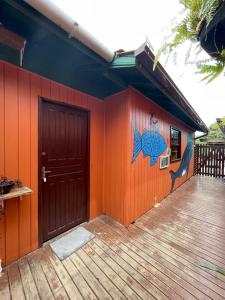 グアルダ・ド・エンバウーにあるHostel Antônio Pescador Guarda do Embauの魚の絵が描かれたオレンジ色の壁の家
