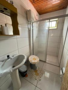 La salle de bains est pourvue d'un lavabo et d'une douche. dans l'établissement Hostel Antônio Pescador Guarda do Embau, à Guarda do Embaú