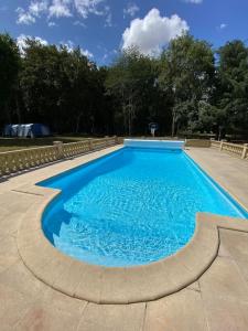 a large blue swimming pool in a yard at Le Cabaret Paisible avec Piscine in Montierchaume