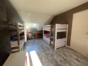 a room with three bunk beds in a attic at Le Cabaret Paisible avec Piscine in Montierchaume