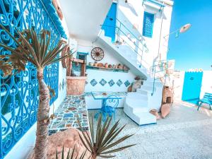 a blue and white house with a staircase and a palm tree at El houch الحوش in Port El Kantaoui