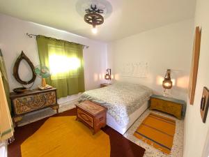 een slaapkamer met een bed, een dressoir en een spiegel bij El houch الحوش in Port El Kantaoui