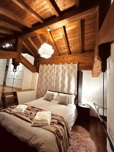 Loft Dei Lupi 260m dal Duomo FreeParking في كريمونا: غرفة نوم بسرير كبير بسقوف خشبية