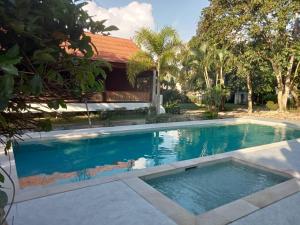 a swimming pool in front of a house at Baan Banyan Villa, wood house short walk to Mae Nam beach in Mae Nam