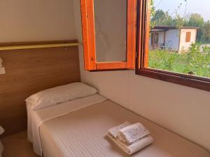 a small room with a bed and a window at Agricamping Corte Pianton in Pacengo di Lazise