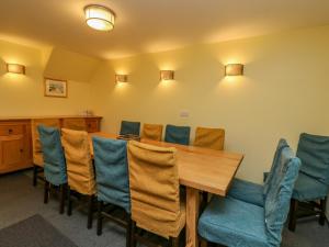 a conference room with a wooden table and blue chairs at The House at Bridge of Lochay in Killin