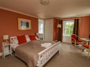 a bedroom with a large bed with orange walls at The House at Bridge of Lochay in Killin