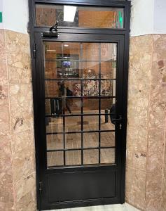 Eine schwarze Tür, durch die eine Person hindurchgeht. in der Unterkunft Casa de Huéspedes Almansa in Madrid