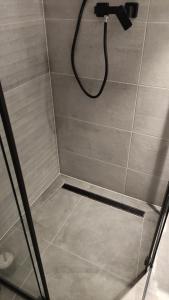 a shower with a shower head in a bathroom at Apartment Between in Krakow +28 photos