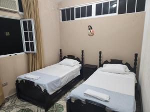 2 camas individuales en una habitación con ventana en Hotel Casa de Don Francisco, en Flores