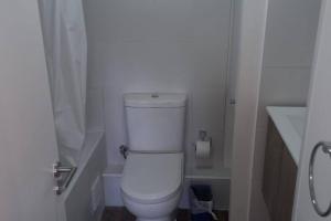 a white bathroom with a toilet and a sink at Comfortable and quiet apartment. Pelluco Alto in Puerto Montt