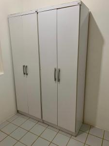 um par de armários brancos num quarto em casa de 4 quartos perto do Forte Orange Itamaracá em Itamaracá
