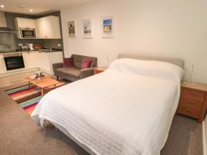1 dormitorio con 1 cama blanca y sala de estar en Silverbirch en Cornhill-on-tweed