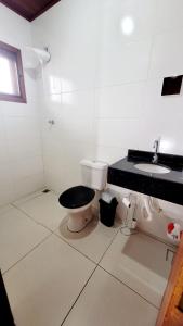 a white bathroom with a toilet and a sink at Casa em Brotas com Piscina e Churrasqueira in Brotas