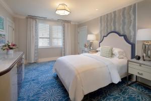 1 dormitorio con 1 cama blanca grande y alfombra azul en The Breakers Palm Beach, en Palm Beach