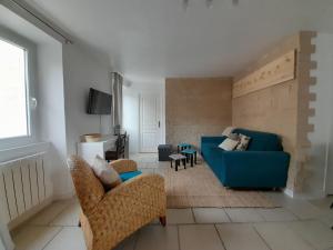ein Wohnzimmer mit einem blauen Sofa und Stühlen in der Unterkunft Côté Château in Gaillon