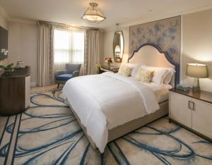 um quarto de hotel com uma cama grande e uma secretária em The Breakers Palm Beach em Palm Beach